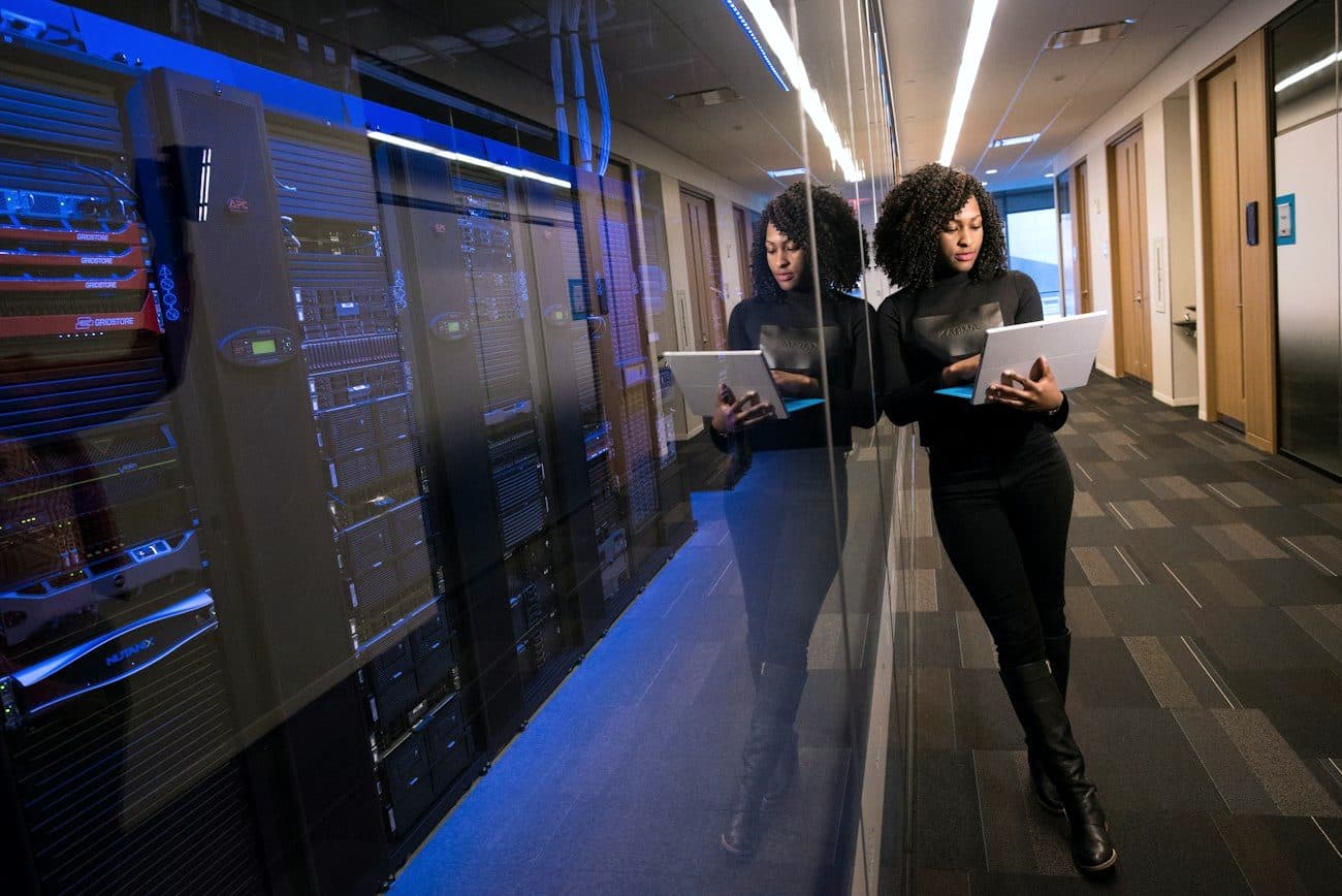 Two colleagues walking a data centre aisle with laptops.